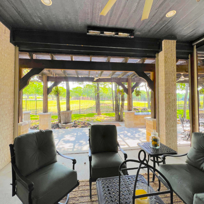 t: RADtec heater above a shaded patio area with green outdoor view and black cushioned seating.