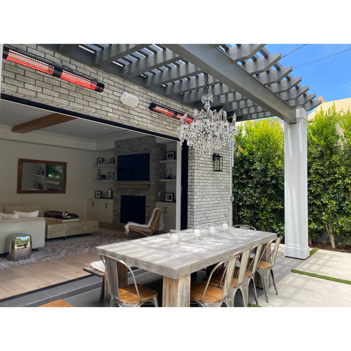 RADtec electric patio heaters over an outdoor dining table set below a chandelier.