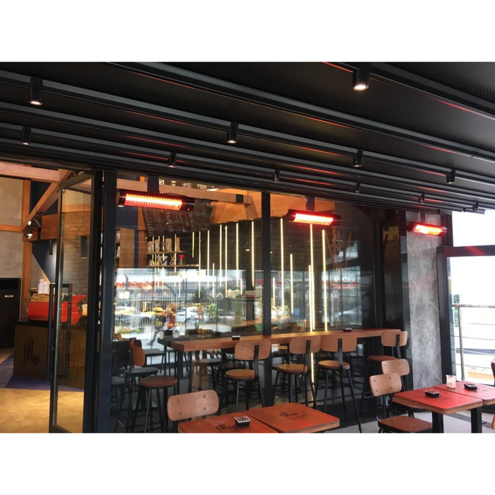 Commercial space featuring RADtec patio heaters glowing red above a bar-style seating area.