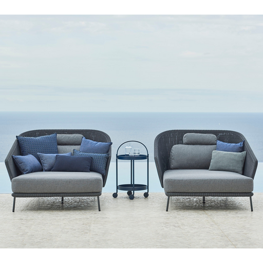 lifestyle image of cane-line mega right daybed in Graphite, Small Round Cane-line Weave Incl. Grey Cane-line AirTouch in a patio with outdoor funiture