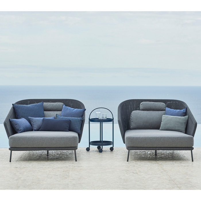 lifestyle image of cane-line mega right daybed in Graphite, Small Round Cane-line Weave Incl. Grey Cane-line AirTouch in a patio with outdoor funiture