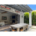 RADtec electric patio heaters over an outdoor dining table set below a chandelier.