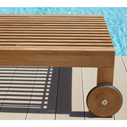 cane-line amaze sunbed teak sunbed without cushion wheels in a pool lifestyle