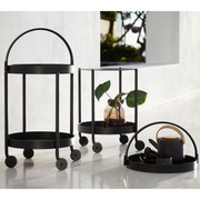 lifestyle image of cane-line roll trolley in black in a lounge