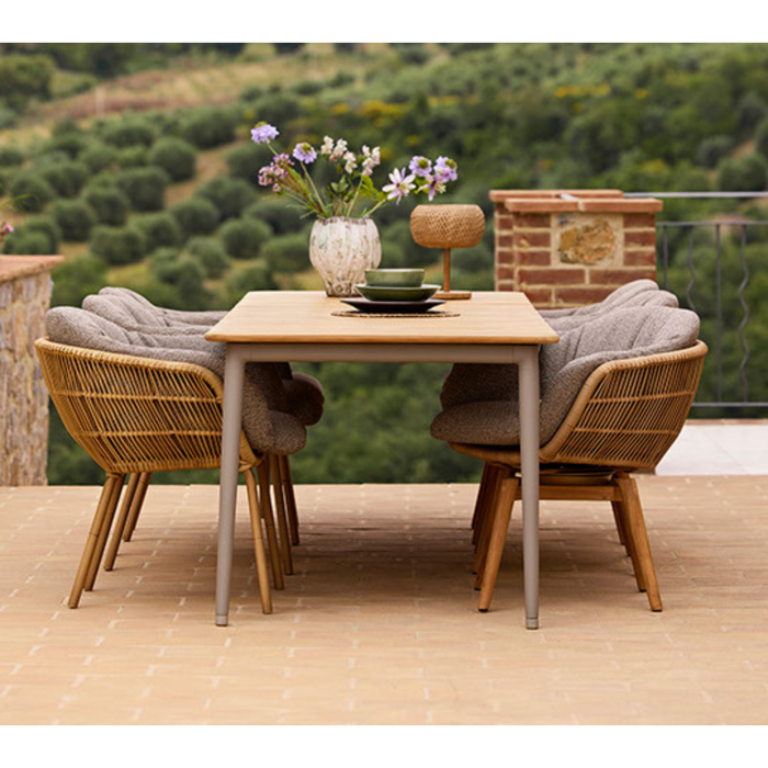 cane-line core dining table 107.9" x 35.5" Taupe Aluminium w/Teak table in a patio with dining chairs lifestyle