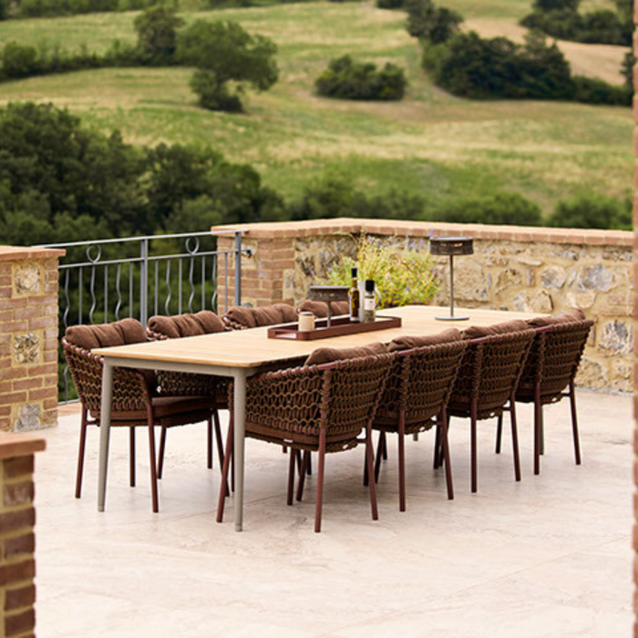 cane-line core dining table 107.9" x 35.5" Taupe Aluminium w/Teak table in a patio with dining chairs lifestyle