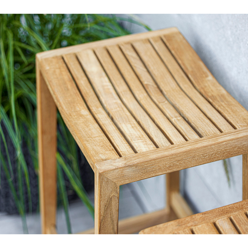 lifestyle image of cane-line flip bar chair in teak in a patio close up