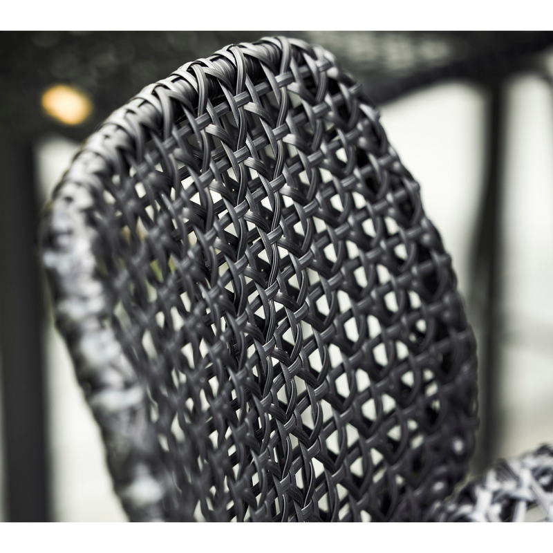 lifestyle image of cane-line vibe bar chair in Black/Graphite, Small Cross Cane-line Weave close up in a patio