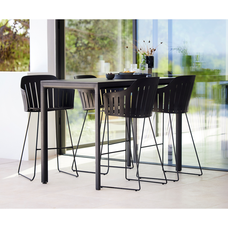 lifestyle image of cane-line choice bar chair in Black, Polypropylene, Up to 98% Recycled chair, Black, Galvanized Steel w/4Legs base and without cushion in a patio with bar table