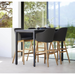lifestyle image of cane-line choice bar chair in Black, Polypropylene, Up to 98% Recycled chair, teak base and Black, Cane-line Natté cushion with bar table in a patio