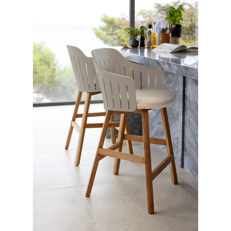 lifestyle image of cane-line choice bar chair in Taupe, Polypropylene, Up to 98% Recycled chair, Teak base and Sand, Cane-line Free cushion in a lounge without back cushion