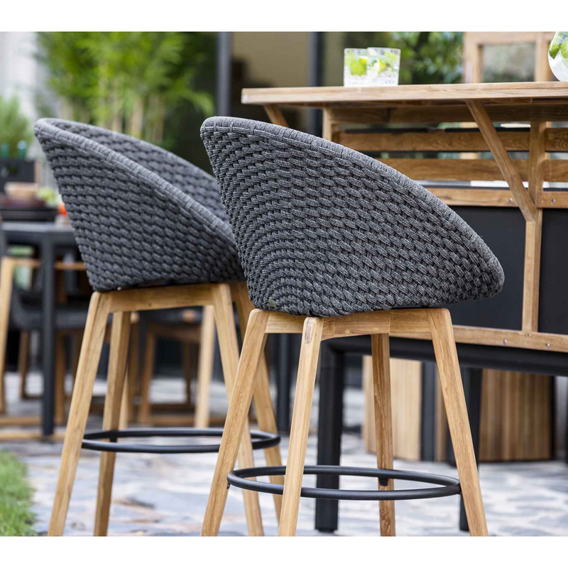 lifestyle image of cane-line peacock bar chair in Dark Grey, Medium Flat Cane-line Soft Rope w/Teak chair with Light Grey, Cane-line Natté cushion in a patio close up