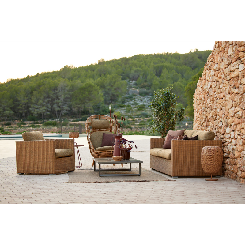 cane line hive chair Natural, small round tube Cane-line Weave with teak base and Turmeric yellow, Cane-line Rise cushion in a patio with outdoor furniture lifestyle
