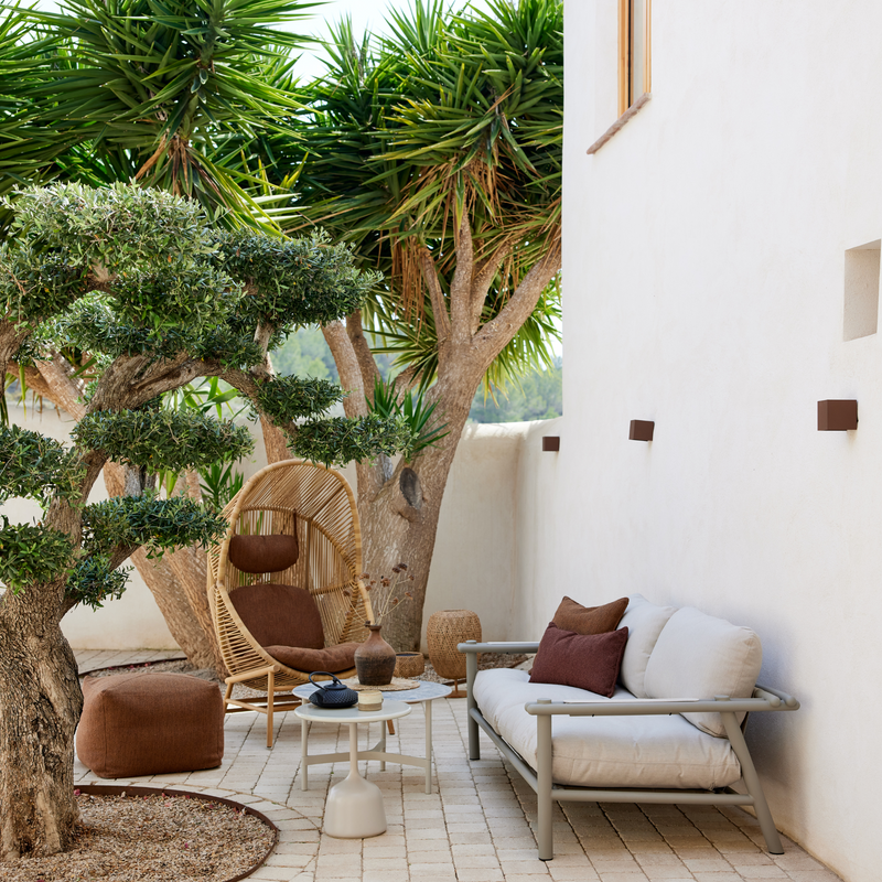 cane line hive chair Natural, small round tube Cane-line Weave with Teak base and Umber brown, Cane-line Rise cushion in a patio with outdoor furniture lifestyle