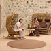 cane-line hive rocking chair Teak base, Natural, Small Round Tube Cane-line Weave chair and Umber Brown, Cane-line Rise cushion in a patio with outdoor furniture and a man enjoying the rocking chair lifestyle