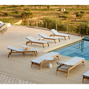 cane-line siesta sunbed teak sunbed with Light grey, Cane-line Virtue cushion in a pool with all the teaks sunbeds lifestyle