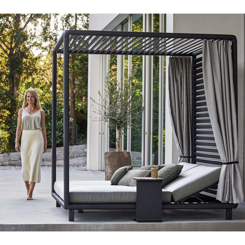 lifestyle image of cane-line laze cabana in Lava Grey, Aluminium Incl. Light Grey Cane-line Natté in a patio with outdoor cushions