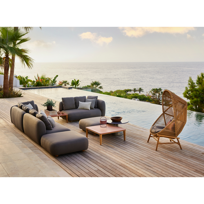 cane-line capture 2 seater sofa module taupe, cane-line airtouch sofa in a patio with pool and outdoor furniture and hive chair lifestyle