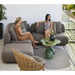 cane-line capture 2-seater sofa left module taupe, cane-line airtouch sofa in a balcony with outdoor furniture and women enjoying the sofa lifestyle