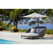 cane-line peacock daybed with parasol in a pool lifestyle
