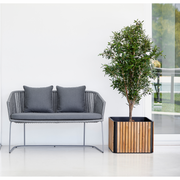 lifestyle image of cane-line combine planter in Square without base type with Teak w/Lava Grey Aluminium color in a patio with outdoor sofa