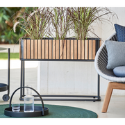 lifestyle image of cane-line combine planter in Rectangular with base type with Teak w/Lava Grey Aluminium color in a patio with outdoor furniture
