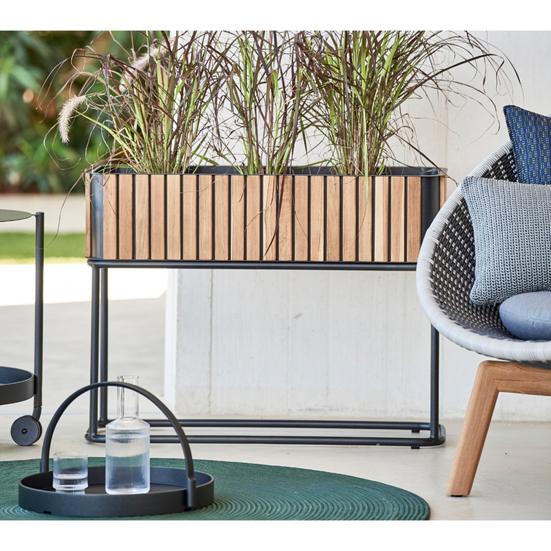 lifestyle image of cane-line combine planter in Rectangular with base type with Teak w/Lava Grey Aluminium color in a patio with outdoor furniture