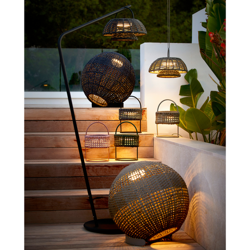  lifestyle image of cane-line illusion lamp round taupe soft rope and dark grey soft rope lit with other lamps in a patio 