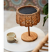 cane-line illusion glow table lamp small natural with teak lit on a coffee table lifestyle