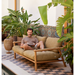 cane-line illusion glow table lamp medium natural with teak with 2-seater sofa in a patio and a man enjoying the sofa lifestyle