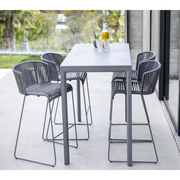 lifestyle image of cane-line moments bar chair in Grey, String Open Cane-line Soft Rope in a patio with bar table