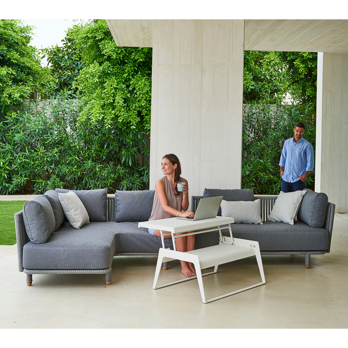 cane-line moments corner module Grey, String Open Cane-line Soft Rope Incl. Grey Cane-line AirTouch cushion in a lounge with outdoor furniture and a woman enjoying the sofa lifestyle