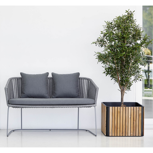 cane-line moments bench Grey, String Open Cane-line Soft Rope bench with Grey, Cane-line Natté cushion in a room with a plant lifestyle