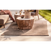 cane-line discover rug taupe in a patio with outdoor furniture and two people enjoying a sofa lifestyle