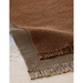 cane-line knit rug 94 x 66 umber brown soft rope and dark sand soft rope in a patio close up lifestyle