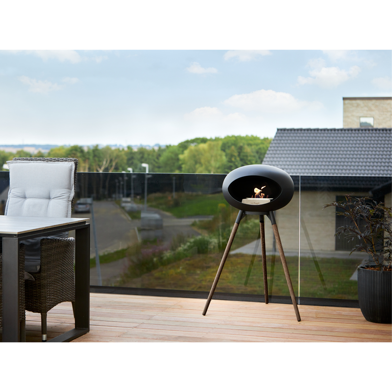 Le Feu Black Dome Bioethanol Fireplace ground high black bowl, smoked legs and steel burner in a patio with outdoor furniture lifestyle