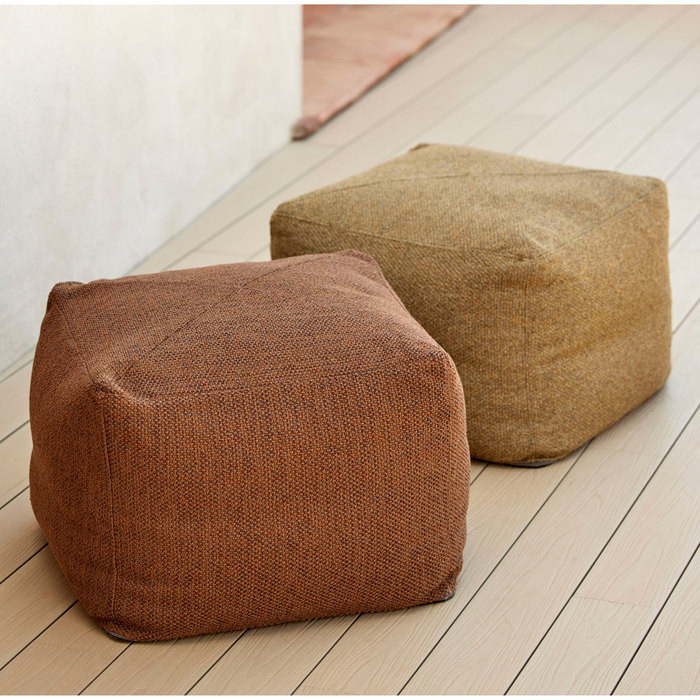 lifestyle image of cane-line divine footstool in Turmeric Yellow, Cane-line Rise and cane-line divine footstool in Umber Brown, Cane-line Rise in a patio