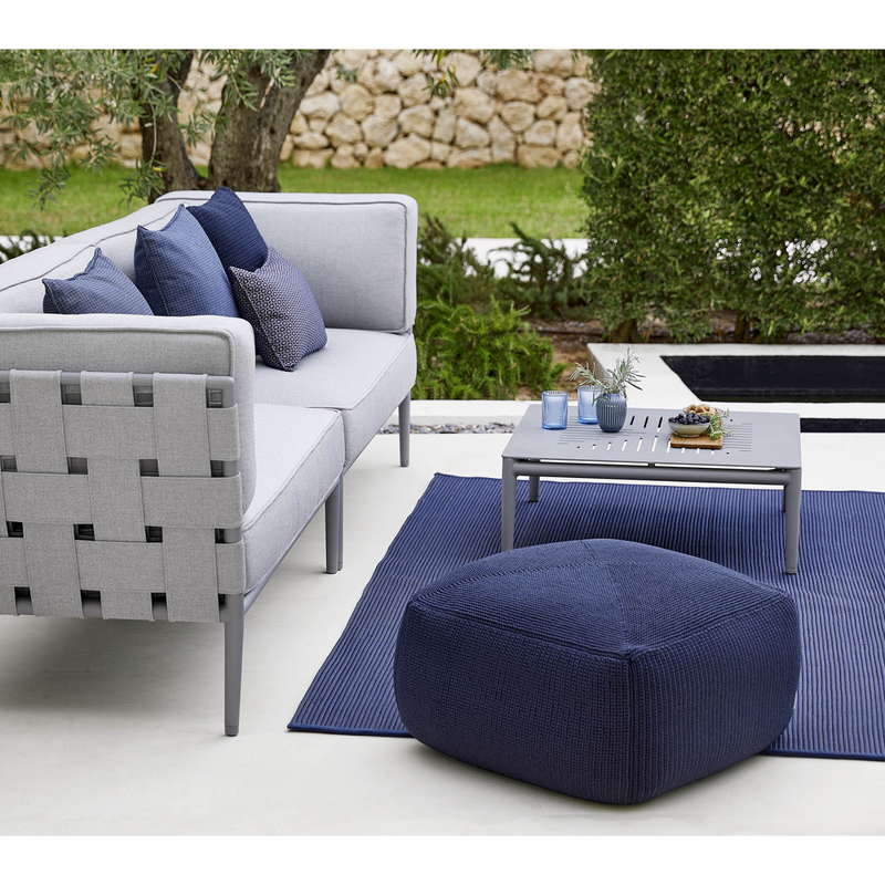 lifestyle image of cane-line divine footstool in Midnight Blue, Cane-line Divine in a patio with outdoor furniture