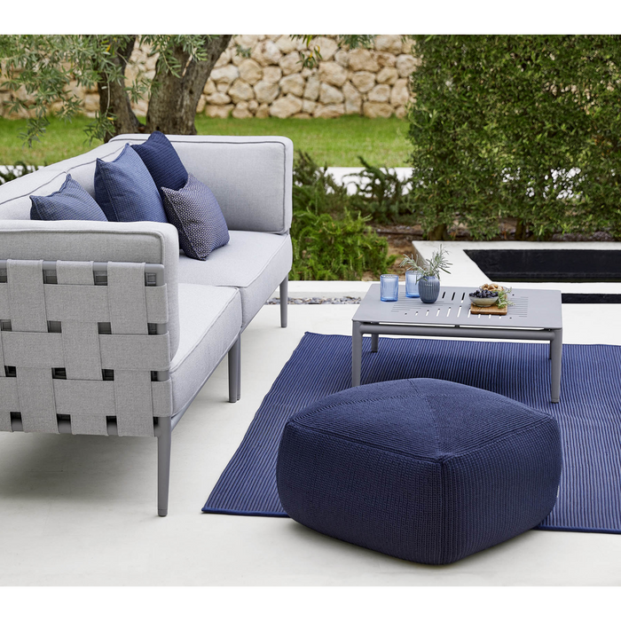 lifestyle image of cane-line divine footstool in Midnight Blue, Cane-line Divine in a patio with outdoor furniture