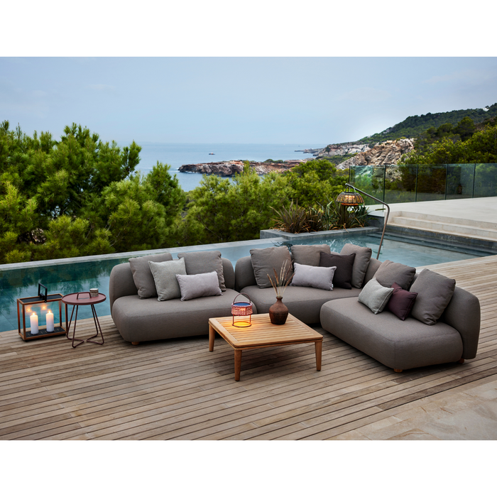 cane-line capture corner sofa taupe, cane-line airtouch sofa in a patio with pool and outdoor furniture lifestyle