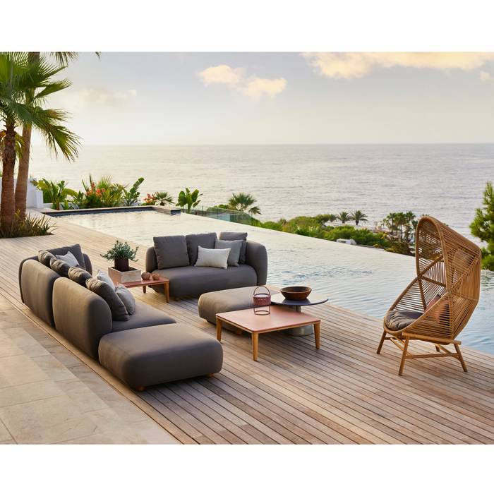 cane-line capture corner sofa taupe, cane-line airtouch sofa in a patio with pool and hive chair lifestyle