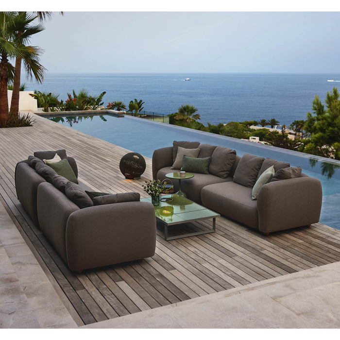 cane-line capture 2 x 2 seater sofa taupe, cane-line airtouch sofa in a patio with pool and outdoor furniture lifestyle