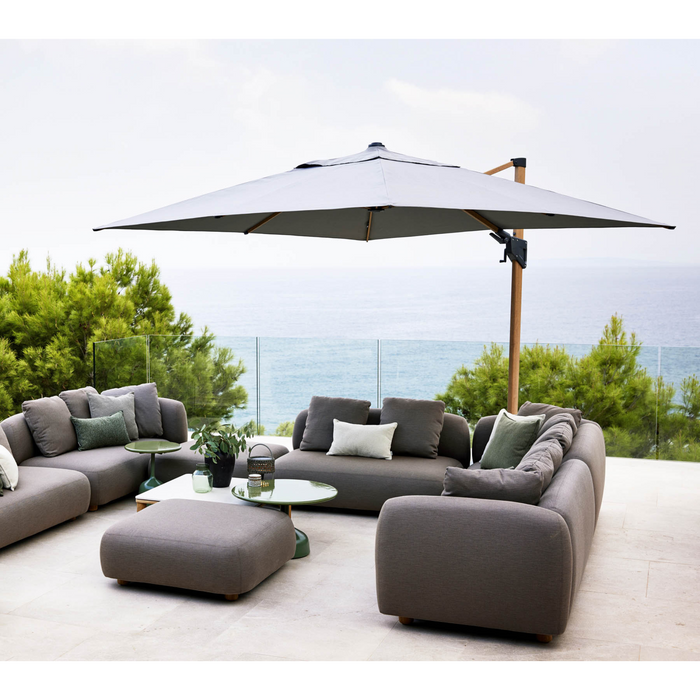 cane-line capture 2 x 2 seater sofa taupe, cane-line airtouch sofa in a patio with parasol lifestyle