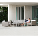 cane-line 6 seater connect dining lounge Taupe, Large Round Cane-line Weave Incl. White Cane-line Natté cushion in a patio with outdoor furniture and a woman enjoying the sofa lifestyle