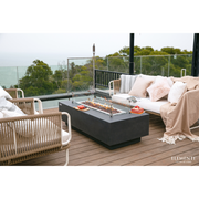 Granville Rectangular Concrete 60" Gas Fire Table in a patio with wind screen and outdoor furniture lifestyle