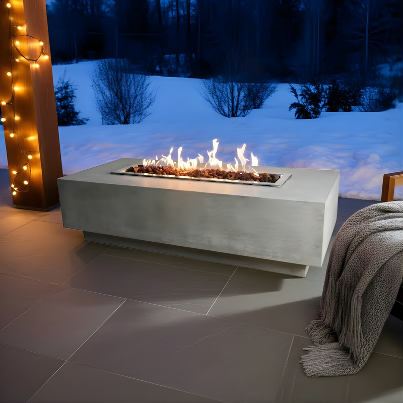Elementi Granville Outdoor fire pit with flames on a snowy night, surrounded by decorative lights and a blanket.