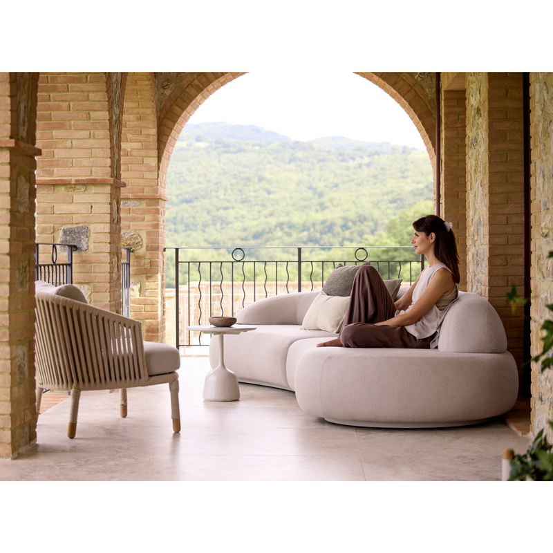 cane-line mellow 4-seater sofa sand, cane-line airtouch sofa in a patio with outdoor furniture and a woman enjoying the sofa lifestyle