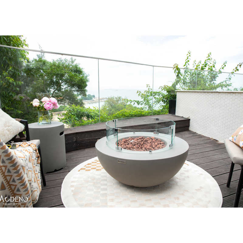 Modeno Roca Fire Table in a patio with wind screen and outdoor furniture lifestyle