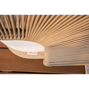 Close-up of a woven malibu chair with Sunbrella cream cushion, featuring the Sunbrella logo.