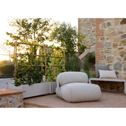 lifestyle image of cane-line sticks planter rack with planter in Teak w/Sand Aluminium with plants in a patio with outdoor furniture